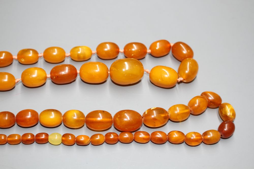 Two single strand graduated oval amber bead necklaces, with yellow metal clasps, one stamped 375,